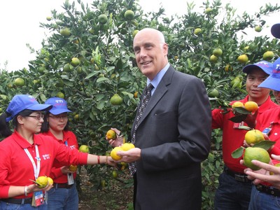 沃爾瑪中國公司事務(wù)高級副總裁博睿（中）考察大理項目基地，并同沃爾瑪員工志愿者一起幫助受助農(nóng)戶收獲成熟的柑橘。